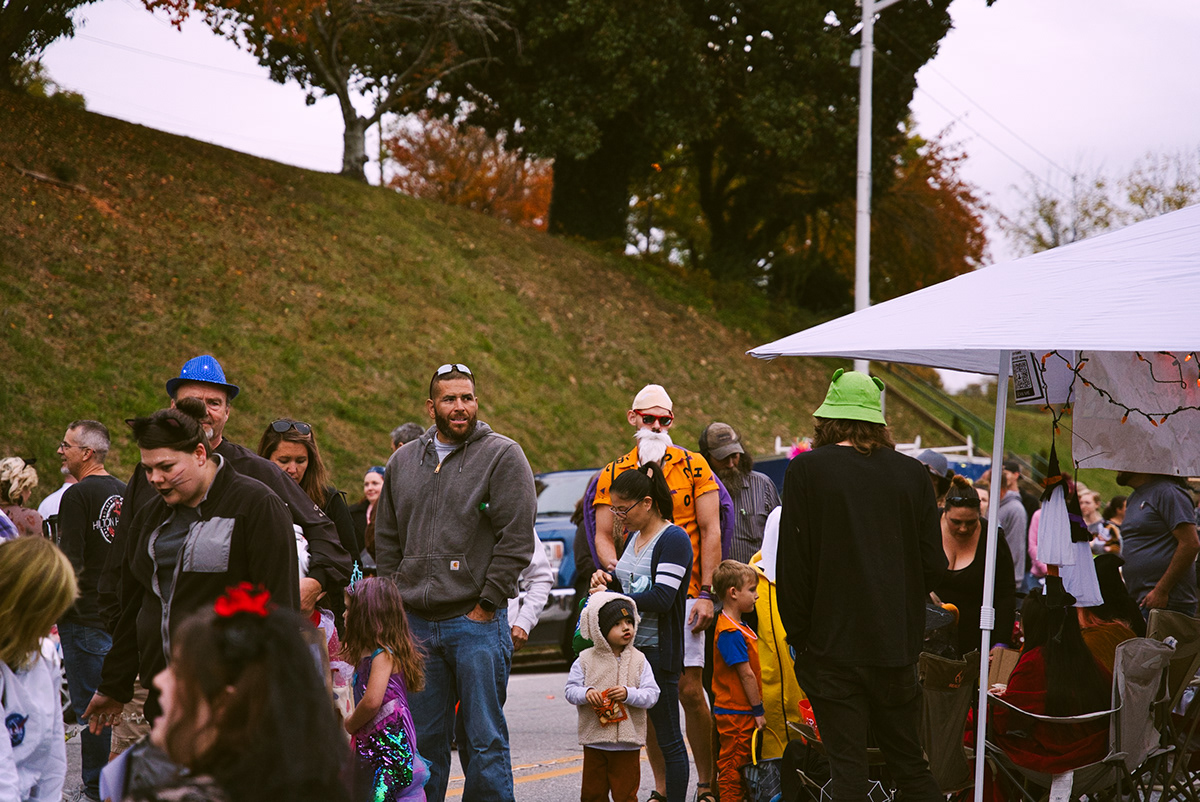 Families and costumed visitors at a street festival
